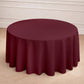 Burgundy seamless polyester round tablecloth on a wooden floor.