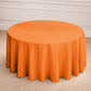 120" orange seamless polyester round tablecloth on a table.