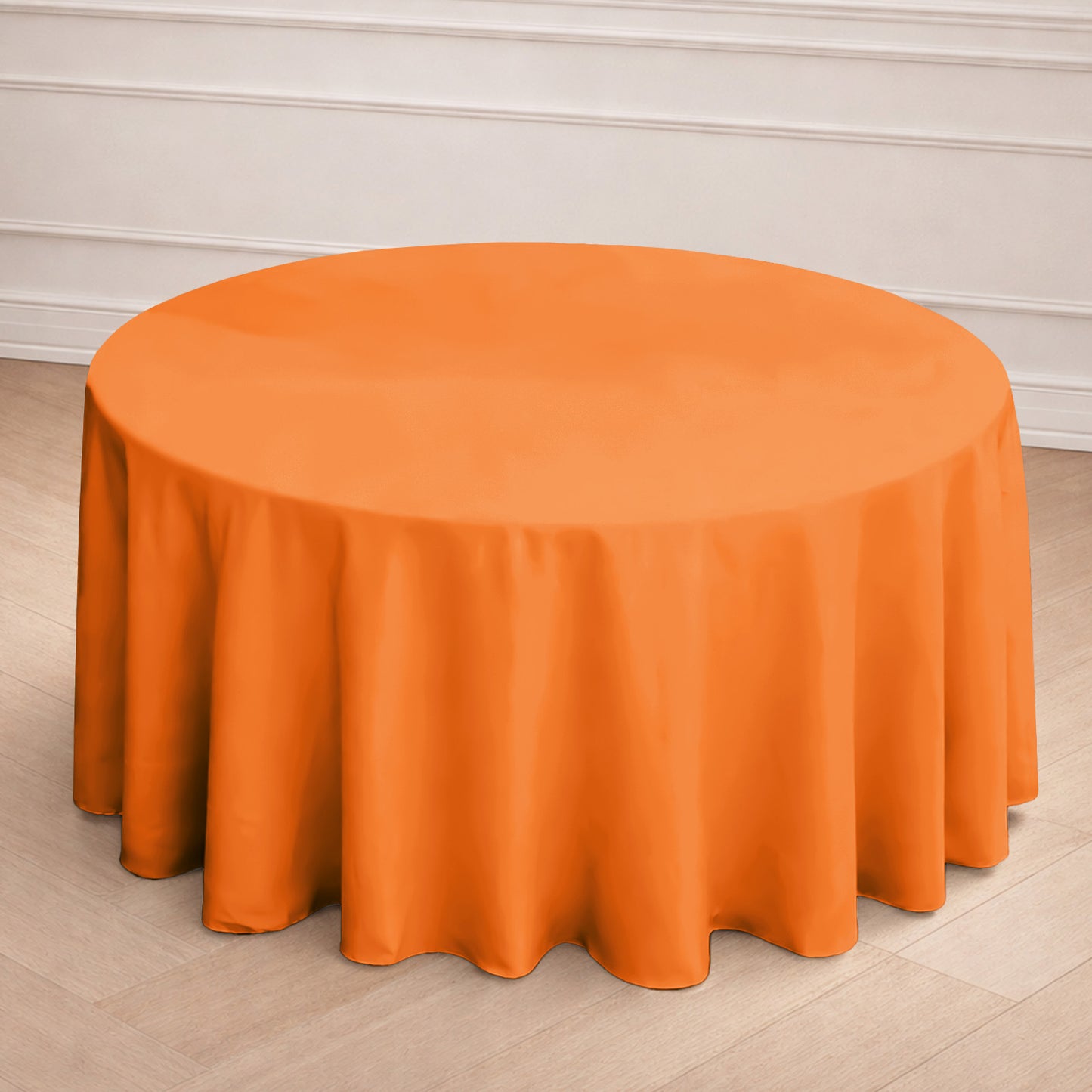 120" orange seamless polyester round tablecloth on a table.