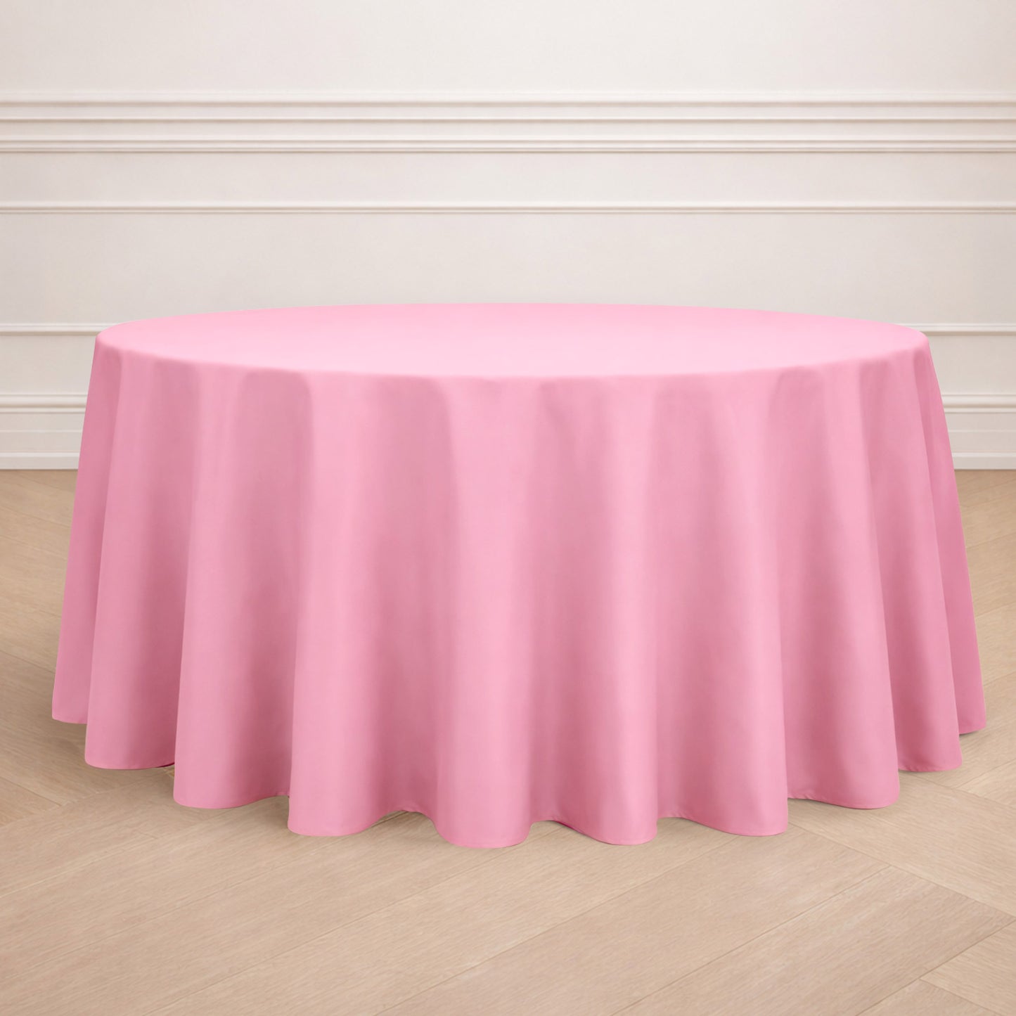 120" Pink Seamless Polyester Round Tablecloth on a wooden floor.