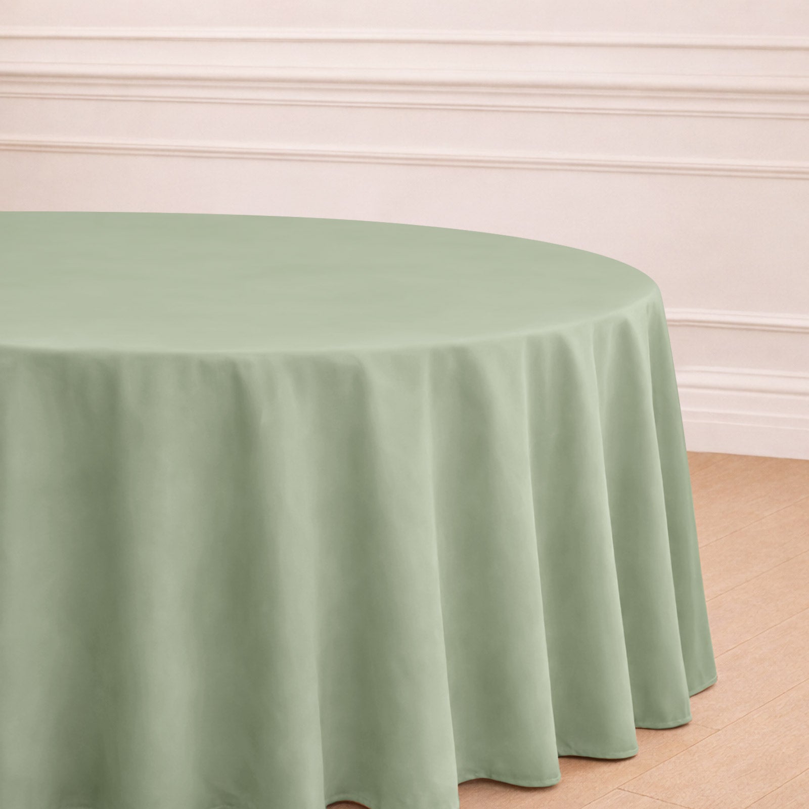 Sage green seamless polyester round tablecloth on a wooden floor.
