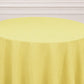 Yellow round tablecloth on a table, perfect for events and gatherings.