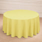 Yellow round tablecloth draping a circular table in a light setting.