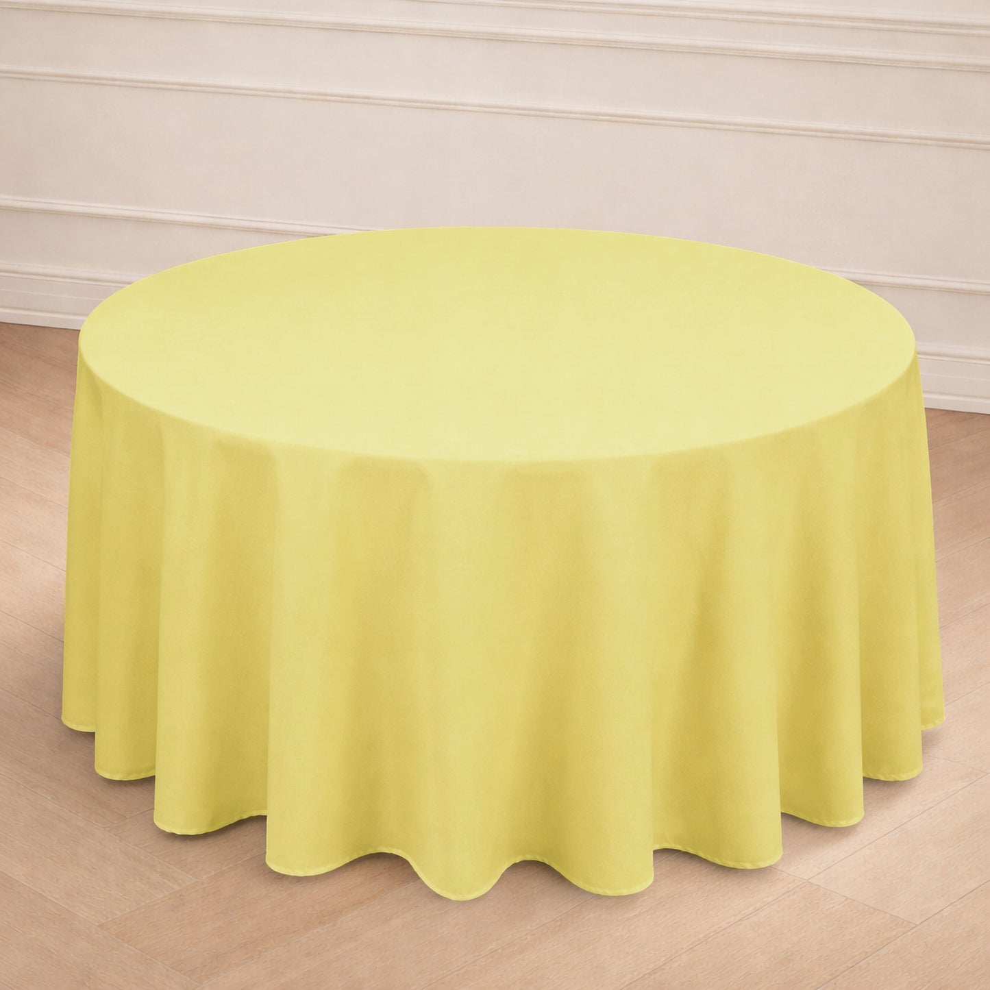 Yellow round tablecloth draping a circular table in a light setting.