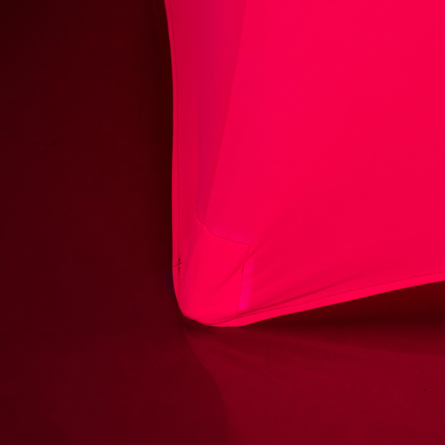 Glow Neon Fuchsia Fitted Spandex Cocktail Tablecloth on a round table.