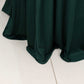 Hunter emerald green round cocktail table cover with natural wavy drapes.