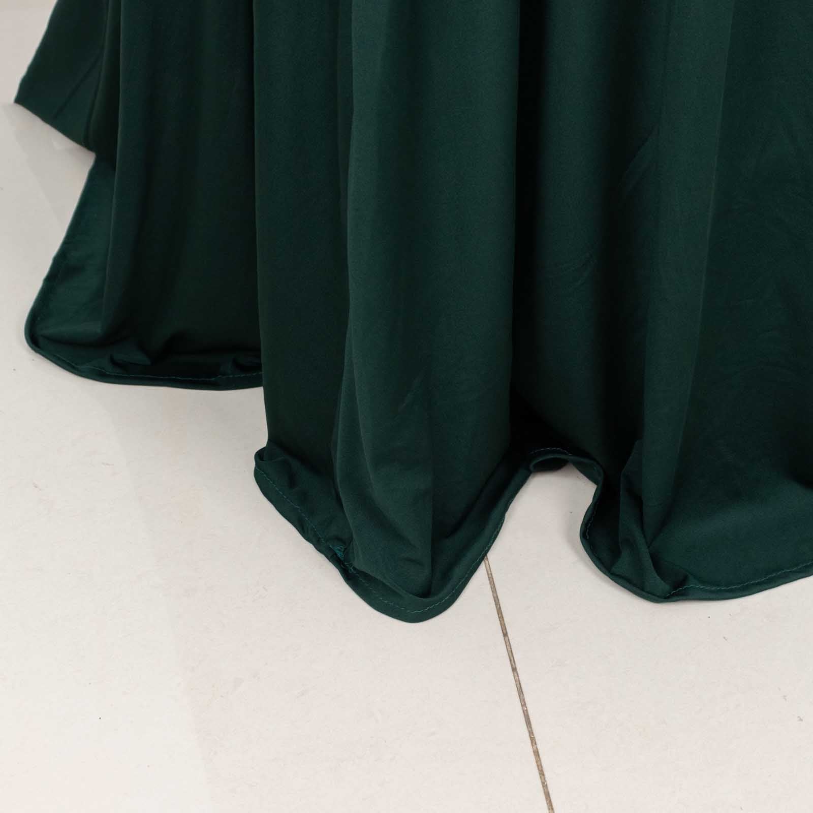 Hunter emerald green round cocktail table cover with natural wavy drapes.