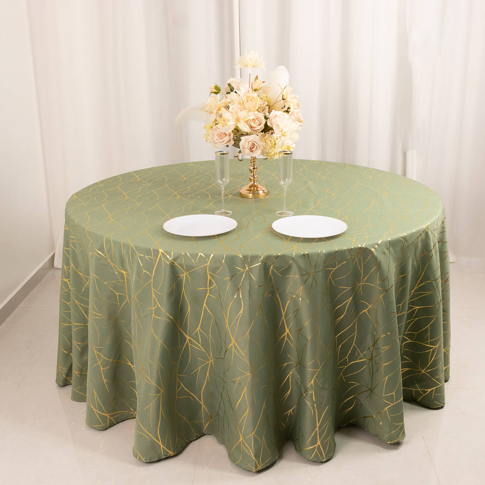 Dusty sage green round tablecloth with gold foil tree branch pattern.