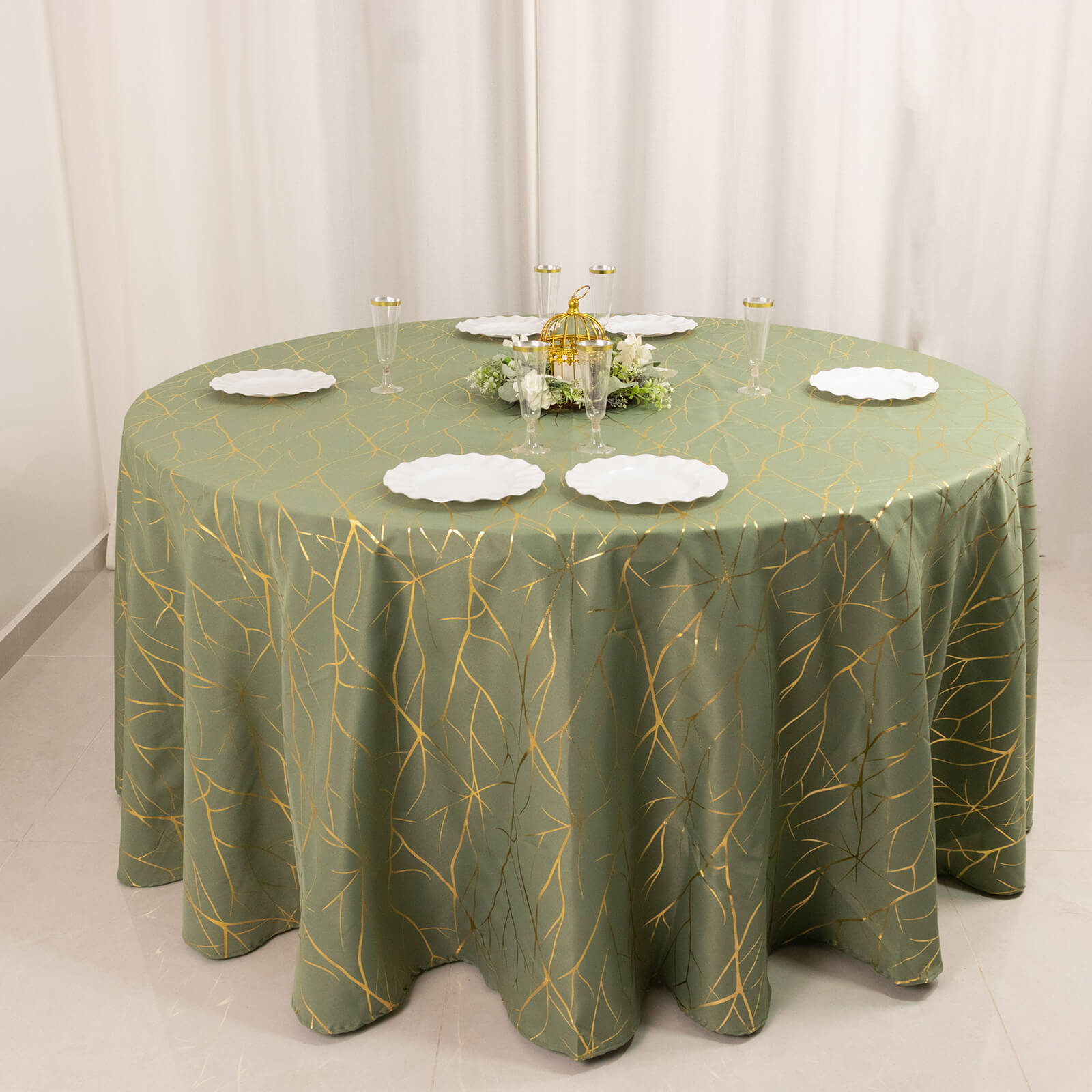 Dusty sage green round tablecloth with gold foil tree branch pattern.