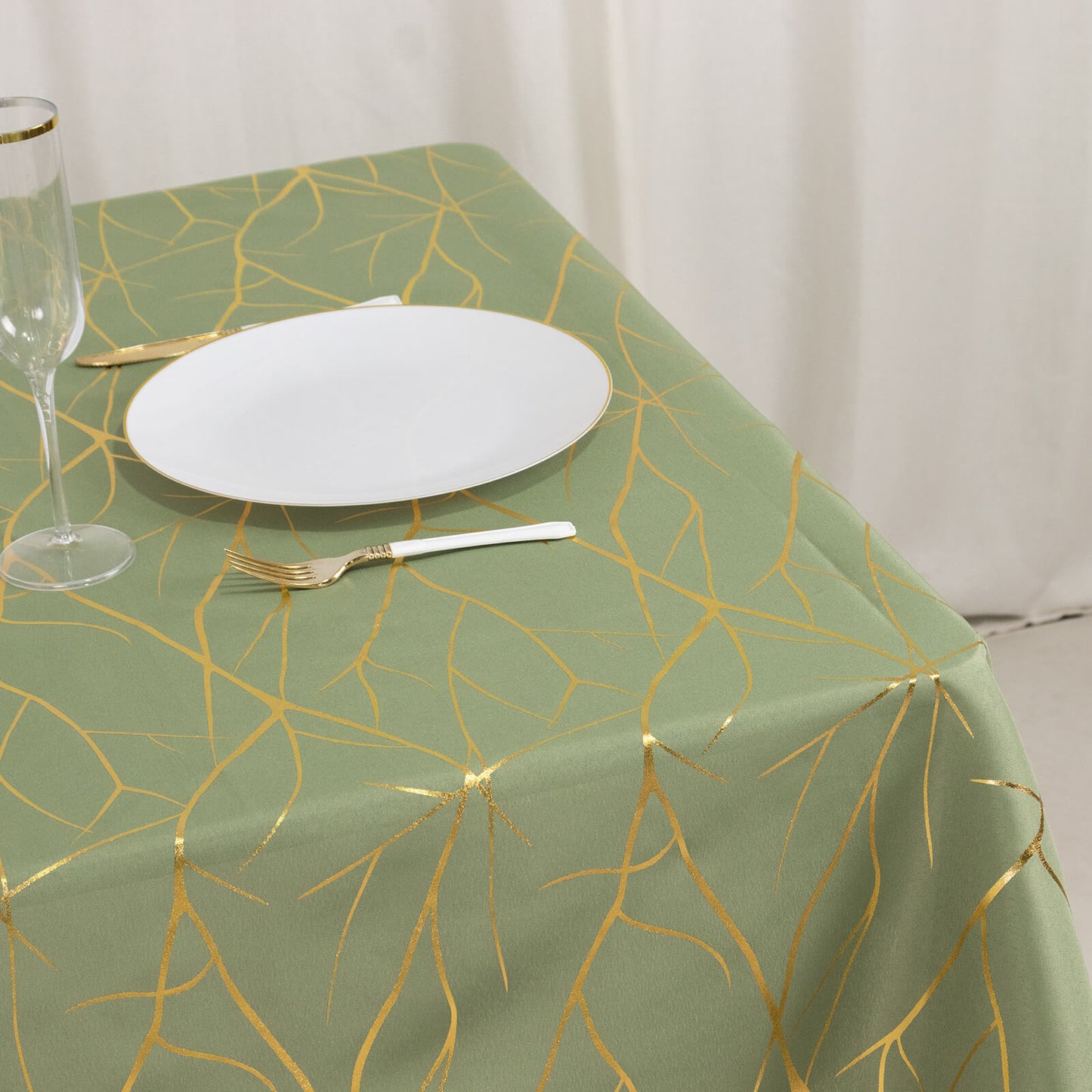 Dusty sage green tablecloth with gold foil tree branch pattern.