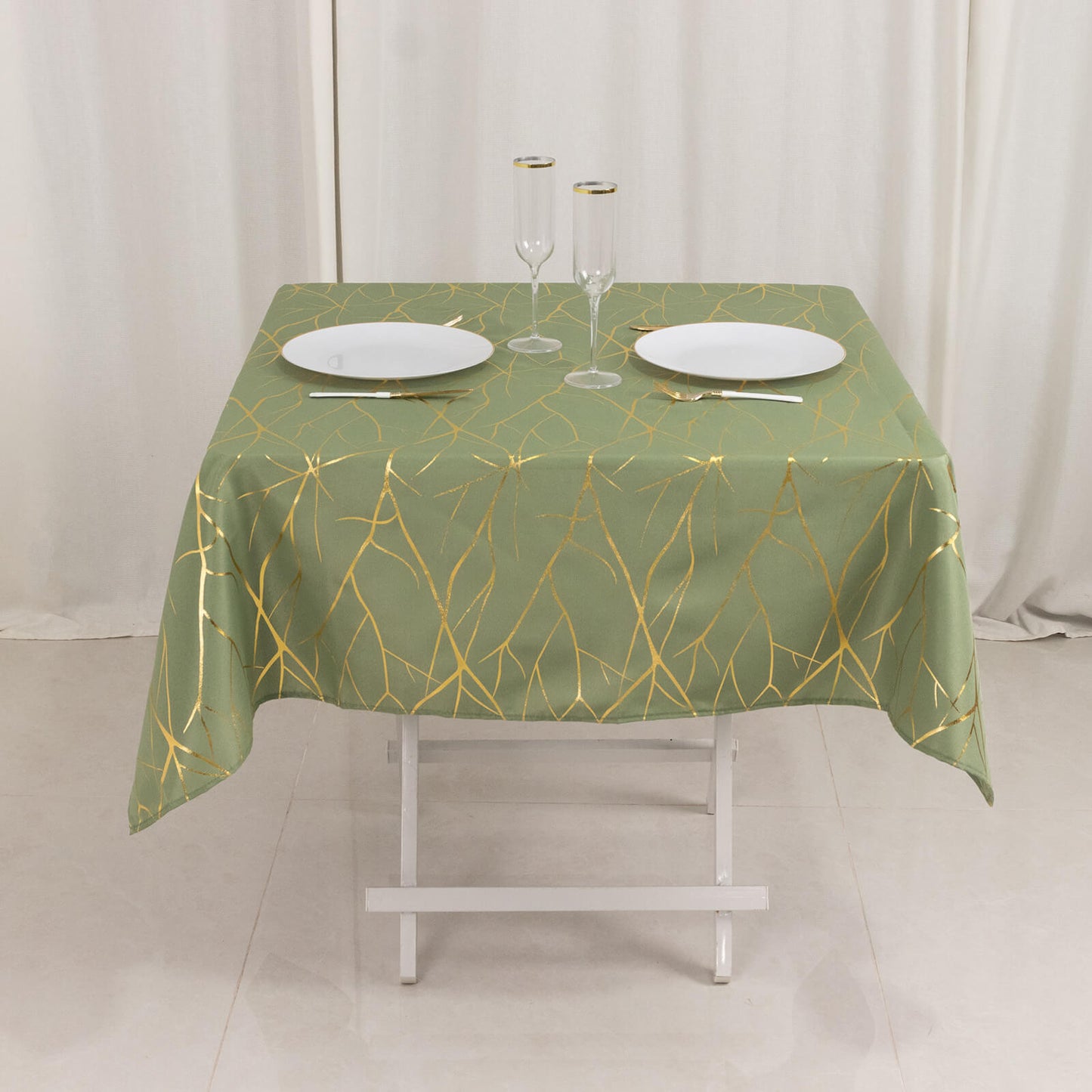 Dusty sage green tablecloth with gold foil tree branch pattern.