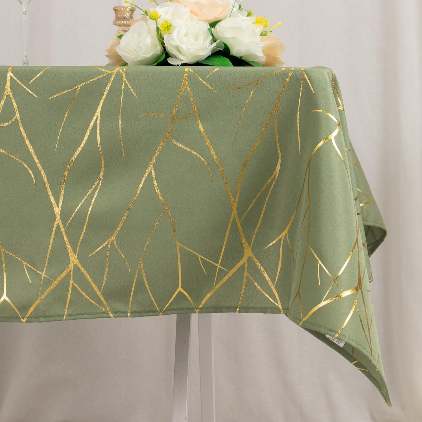 Dusty sage green tablecloth with gold foil tree branch pattern.
