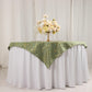 Dusty sage green table overlay with gold foil tree branch pattern.