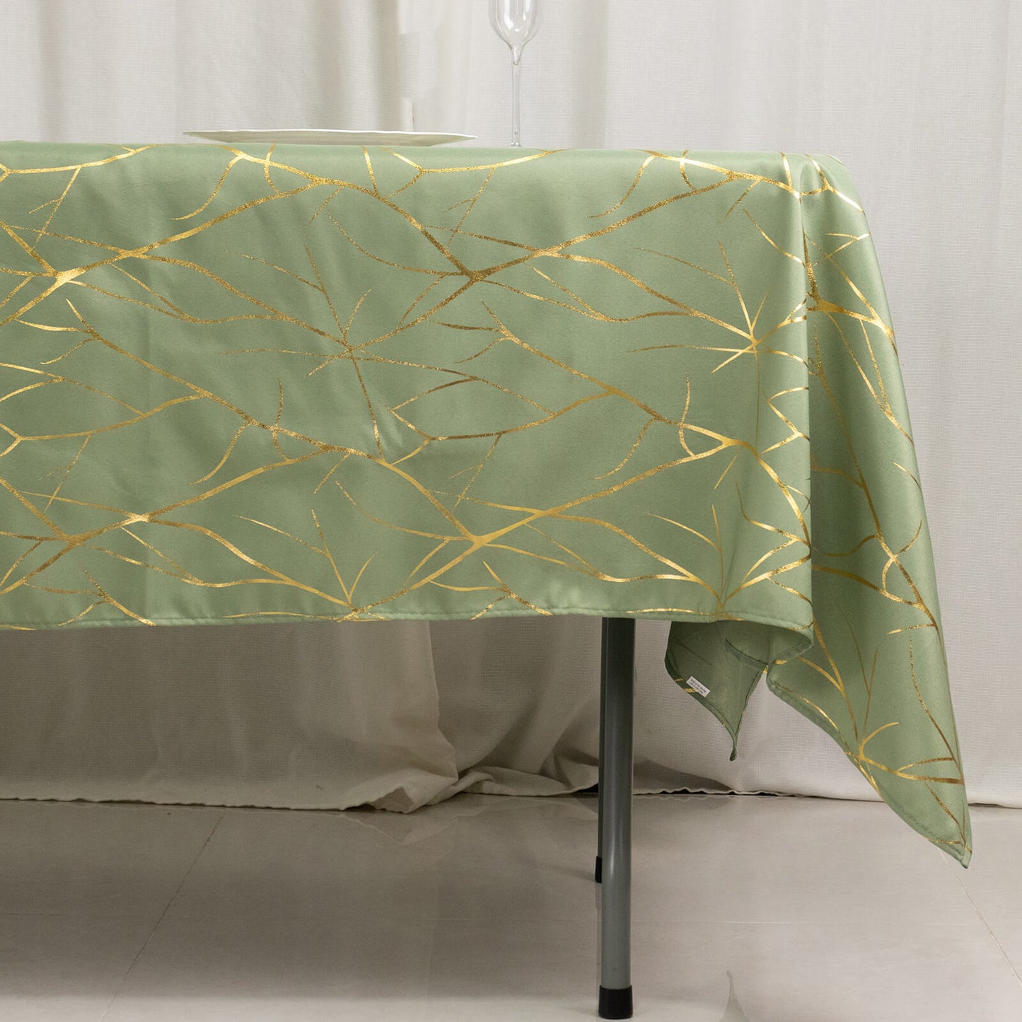 Dusty sage green tablecloth with gold foil tree branch pattern.