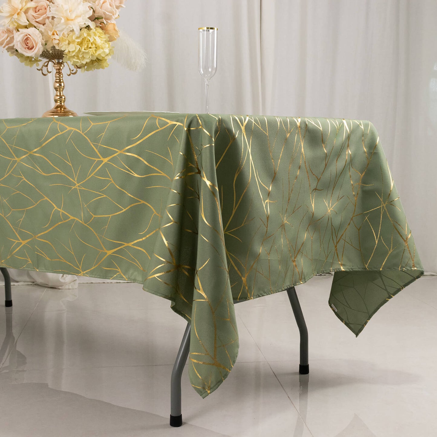 Dusty sage green tablecloth with gold foil tree branch pattern.