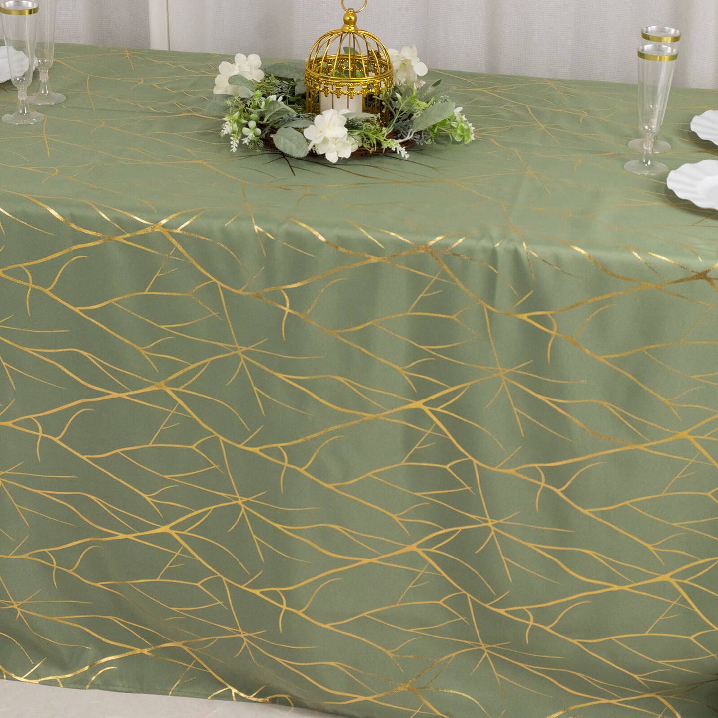 Dusty sage green tablecloth with gold foil tree branch pattern.