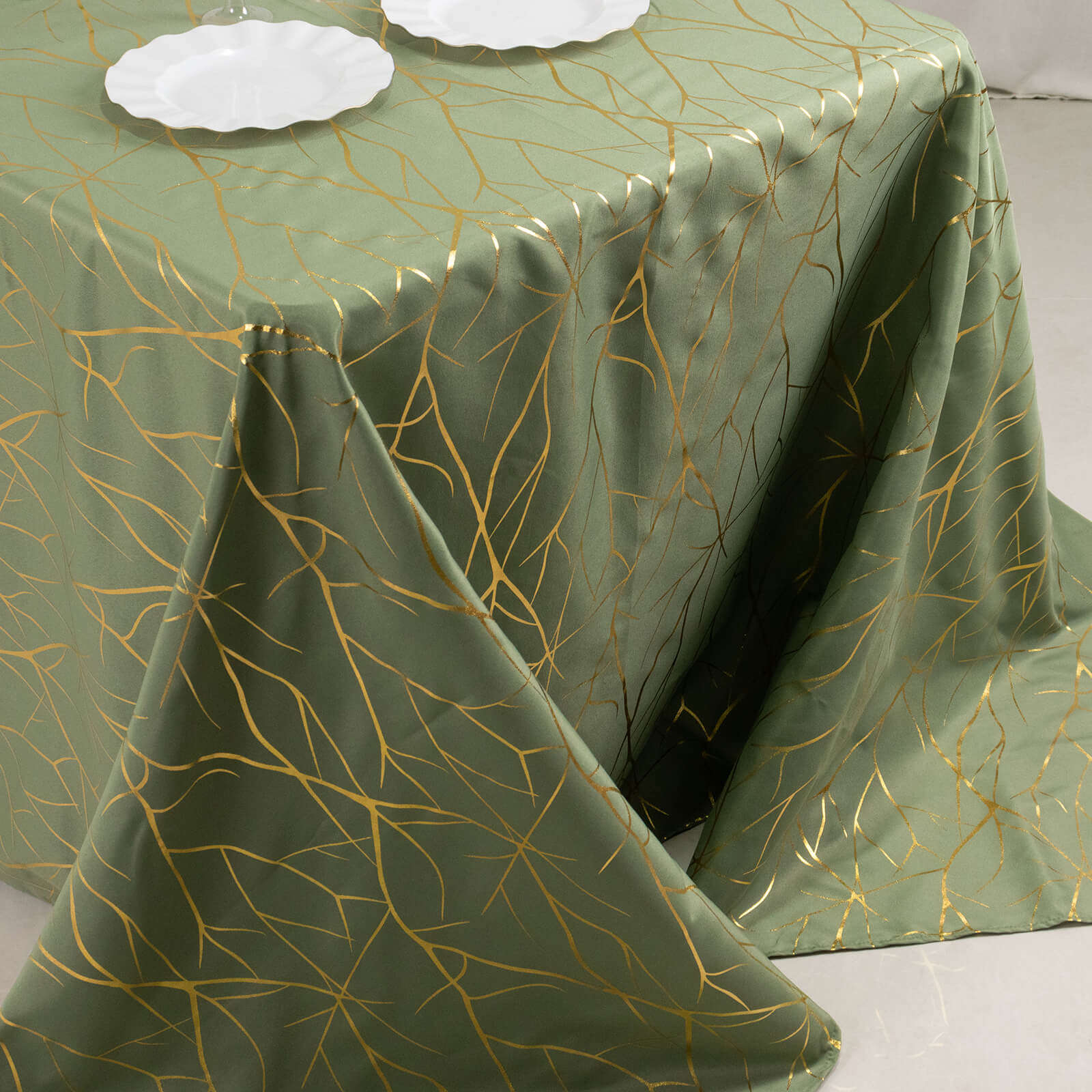 Dusty sage green tablecloth with gold foil tree branch pattern.