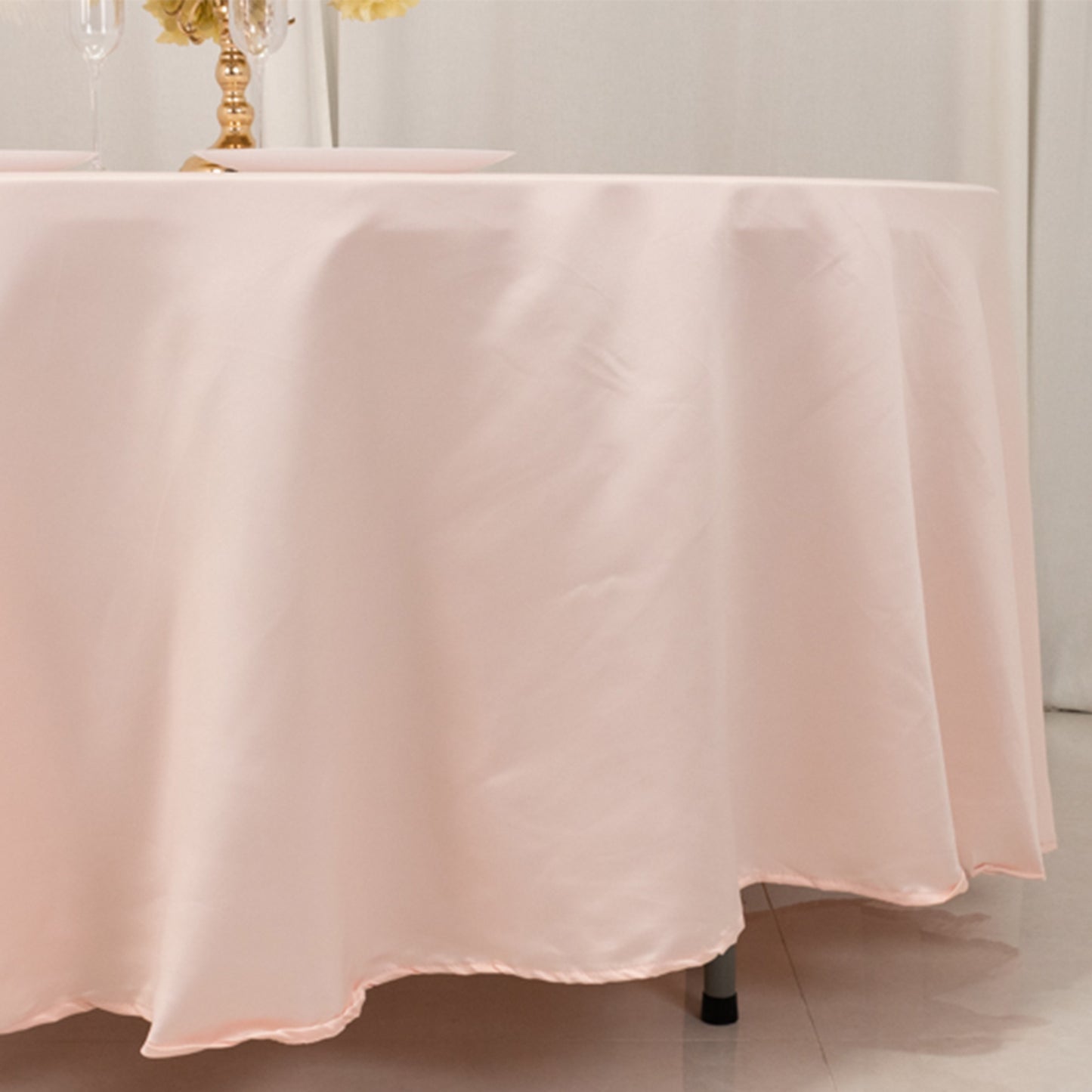 Blush satin round tablecloth draping elegantly over a table.