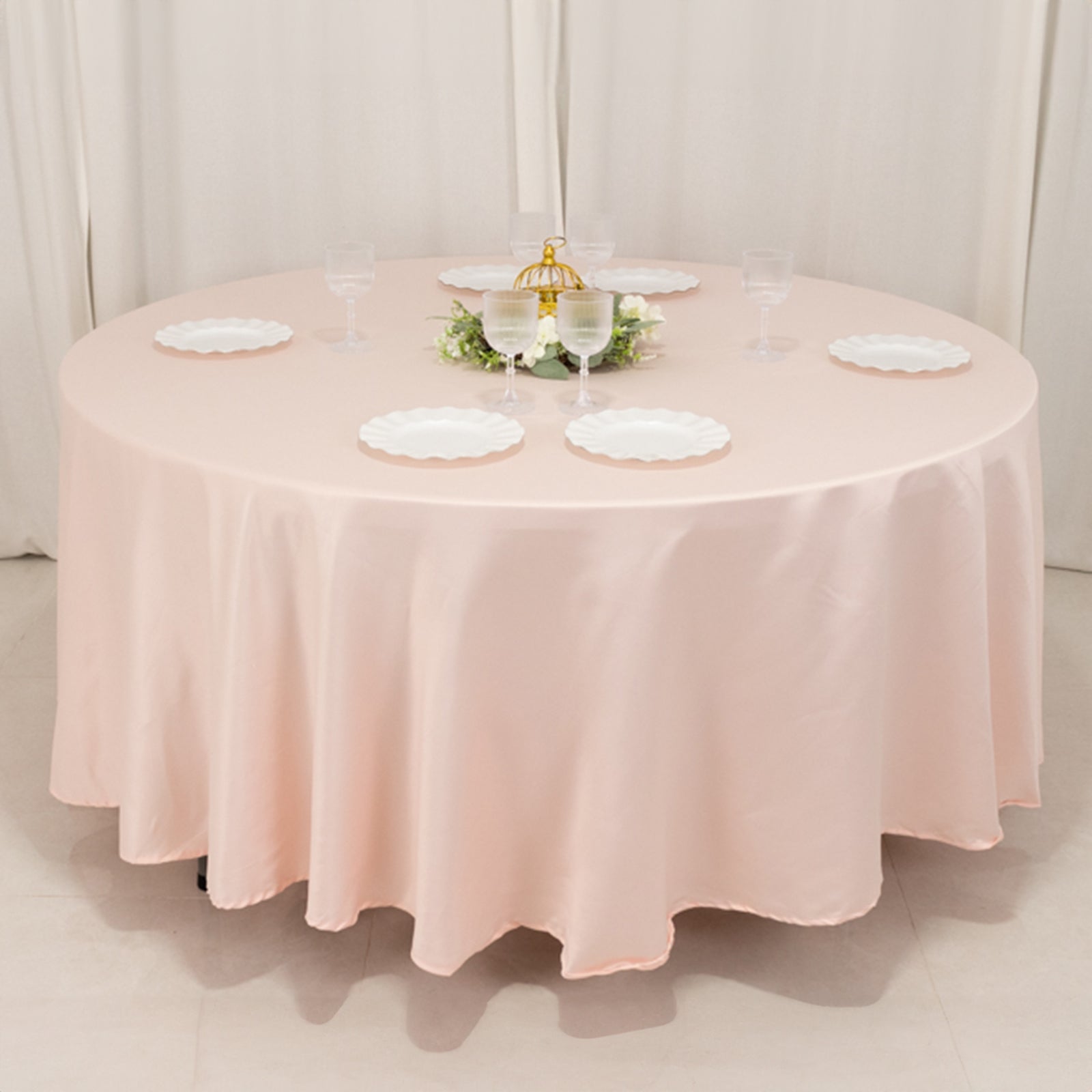 Blush satin round tablecloth set on a round dining table.