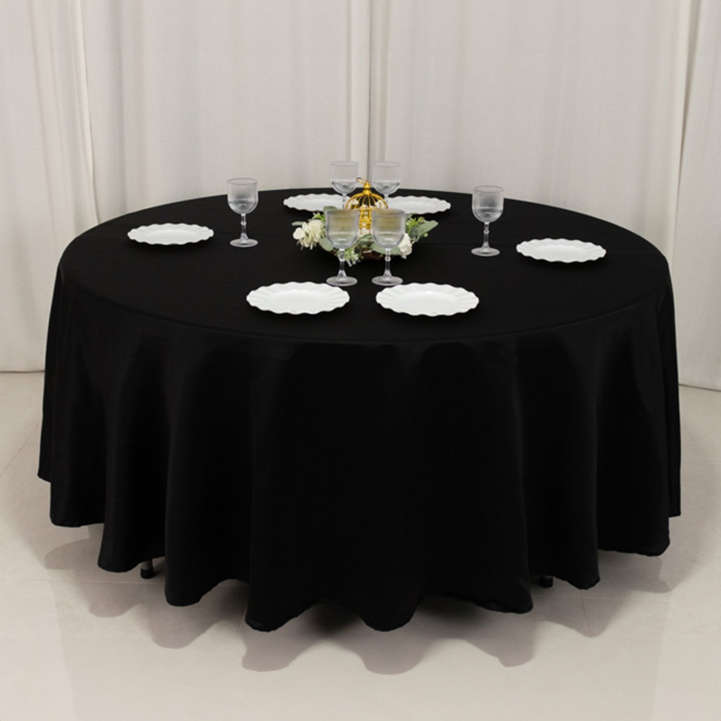Black round tablecloth, 108 inches, elegantly draped on a table.