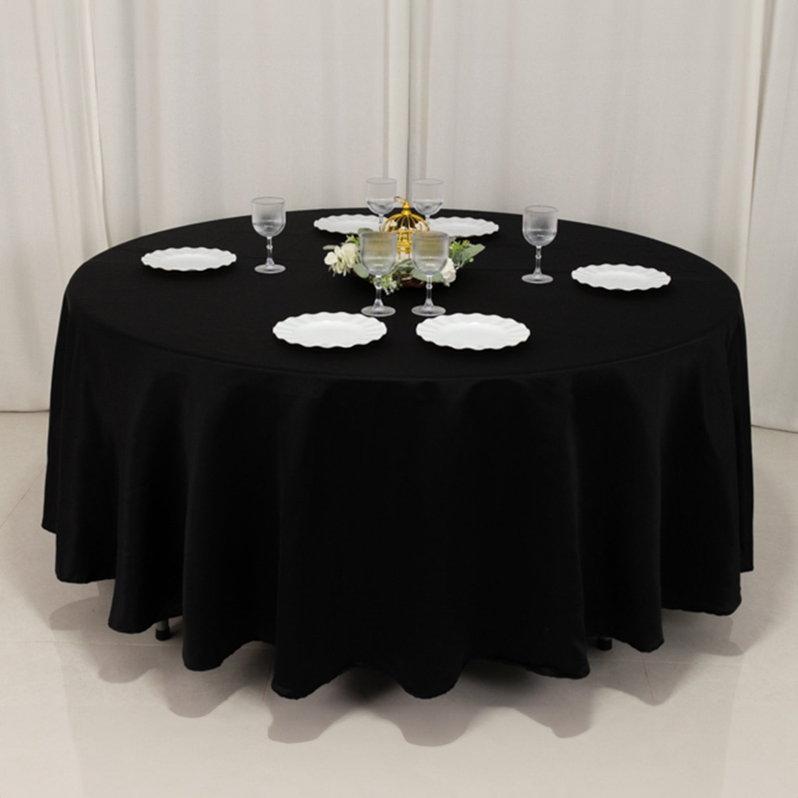 Black round tablecloth, 108 inches, elegantly draped on a table.