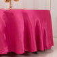 Fuchsia satin round tablecloth on a dining table.