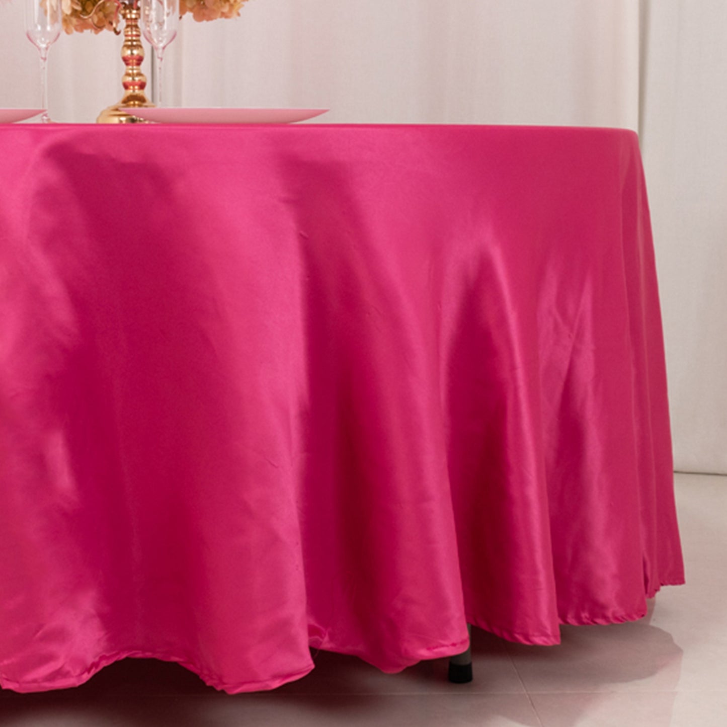 Fuchsia satin round tablecloth on a dining table.