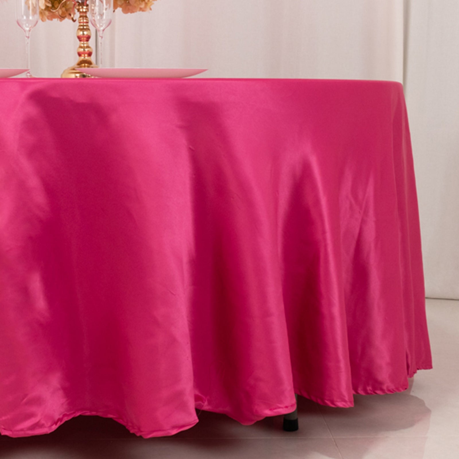 Fuchsia satin round tablecloth on a dining table.