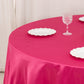 Fuchsia round satin tablecloth with white plates on a table.
