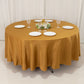 Gold round tablecloth with elegant setting and glassware.