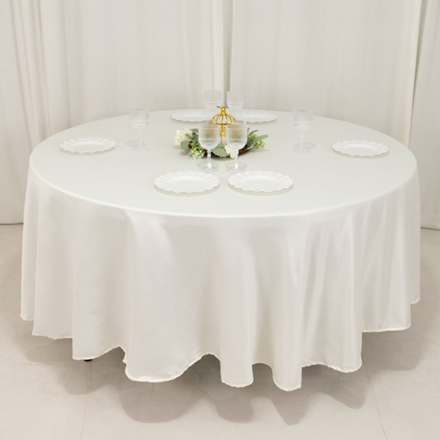Ivory round satin tablecloth for elegant table settings.