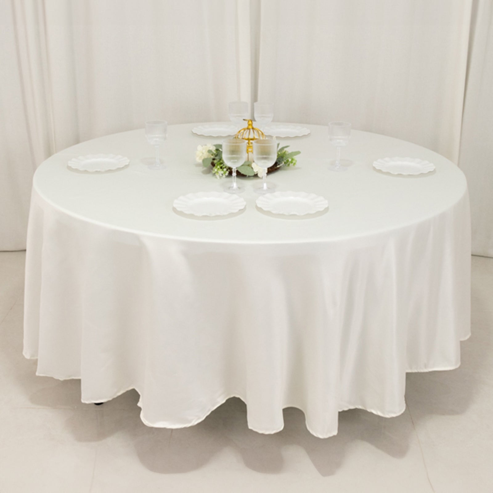 Ivory round satin tablecloth for elegant table settings.
