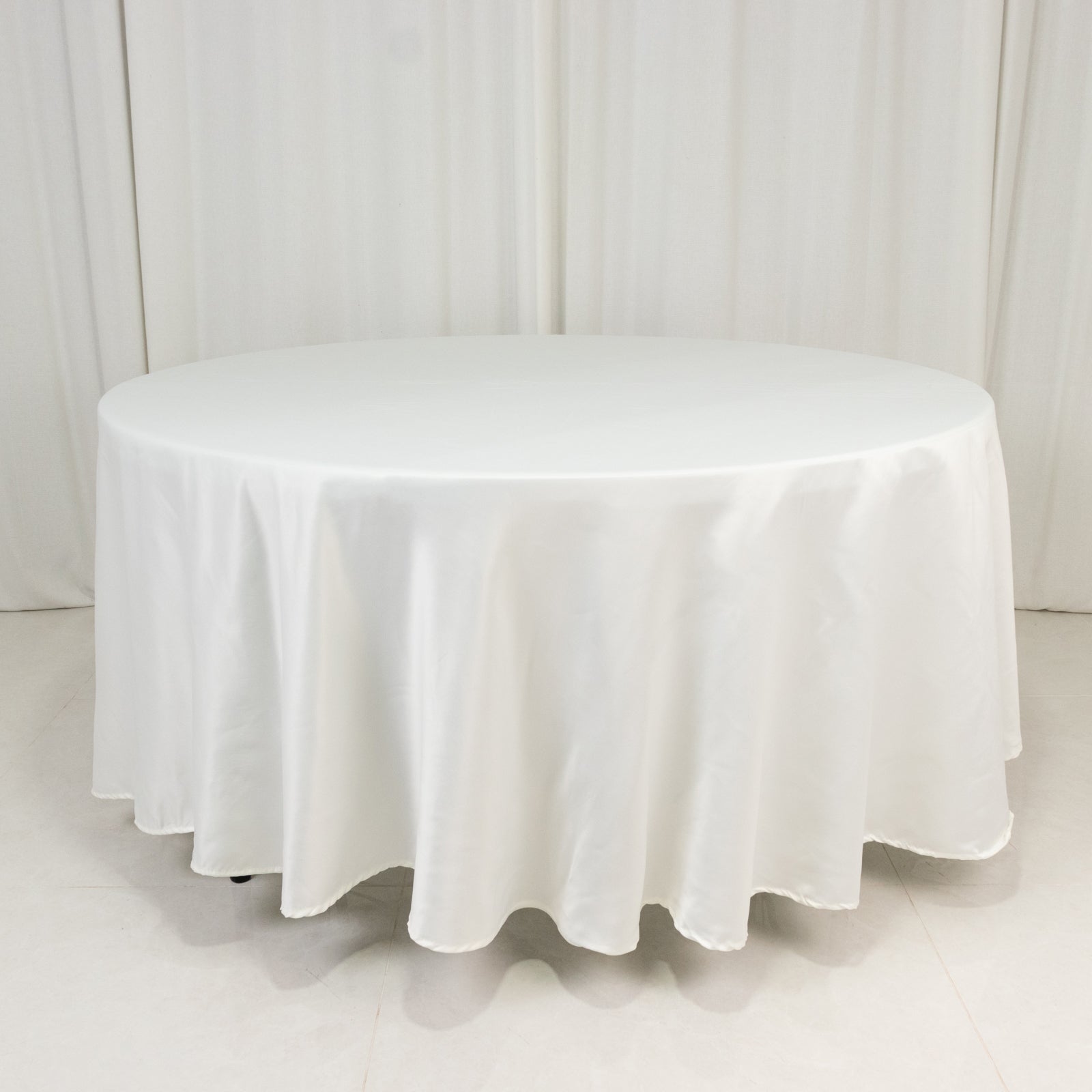 Ivory satin round tablecloth for elegant table settings.