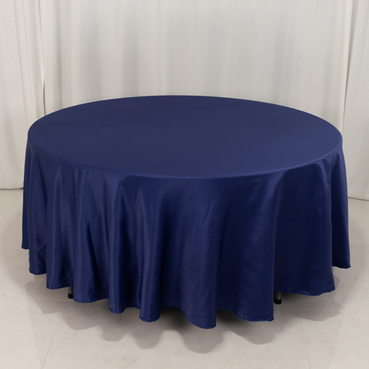 Navy blue round satin tablecloth draping elegantly over a table.