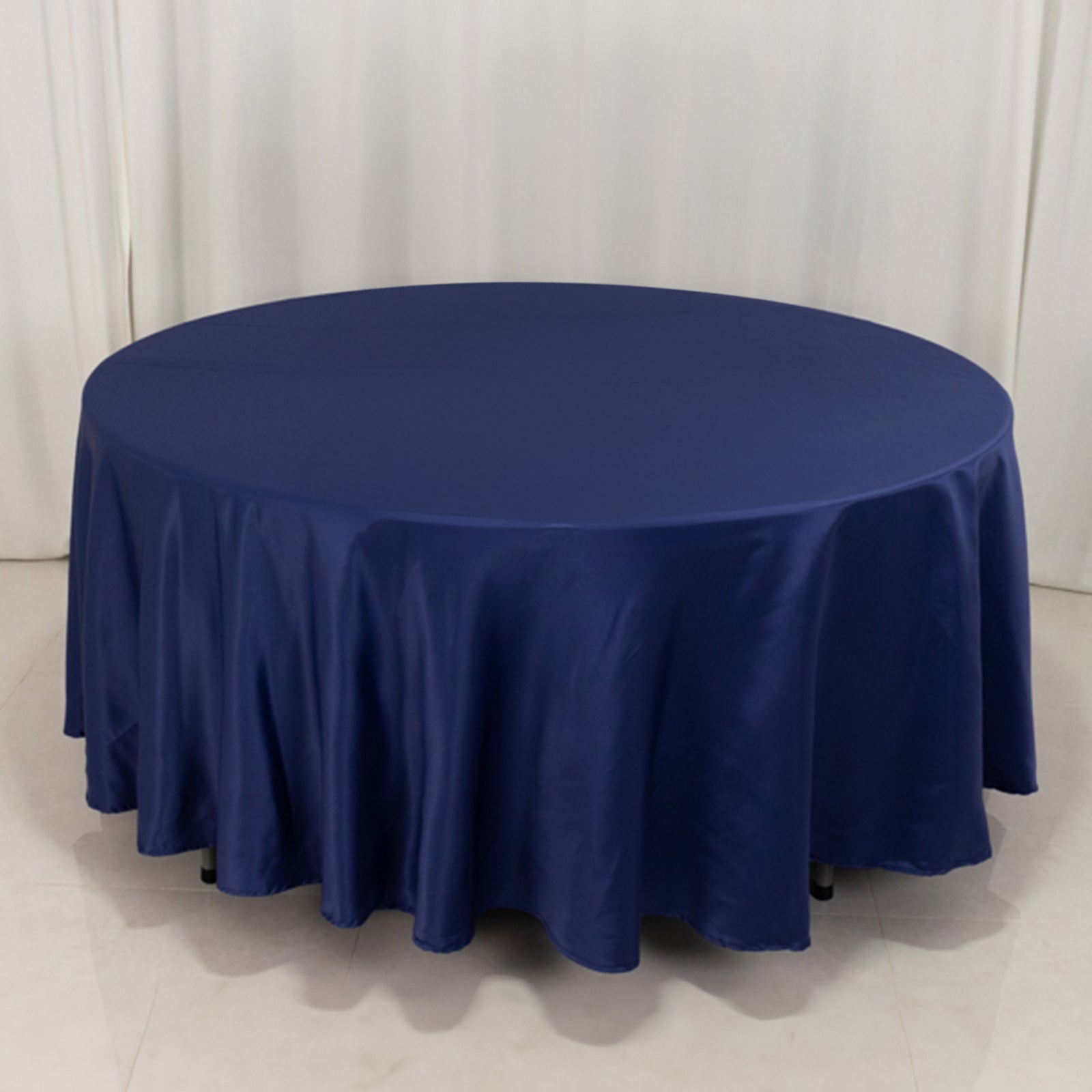 Navy blue round satin tablecloth draping elegantly over a table.