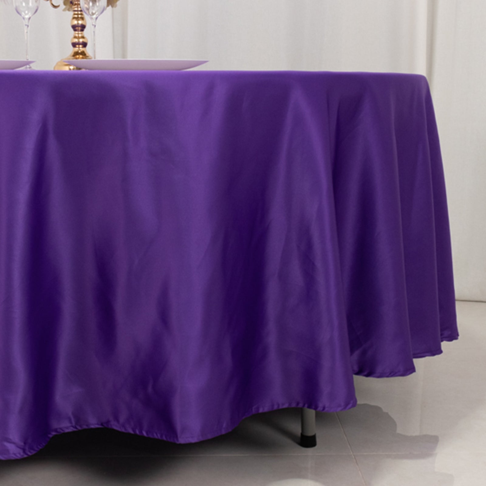 Purple satin round tablecloth on a dining table.