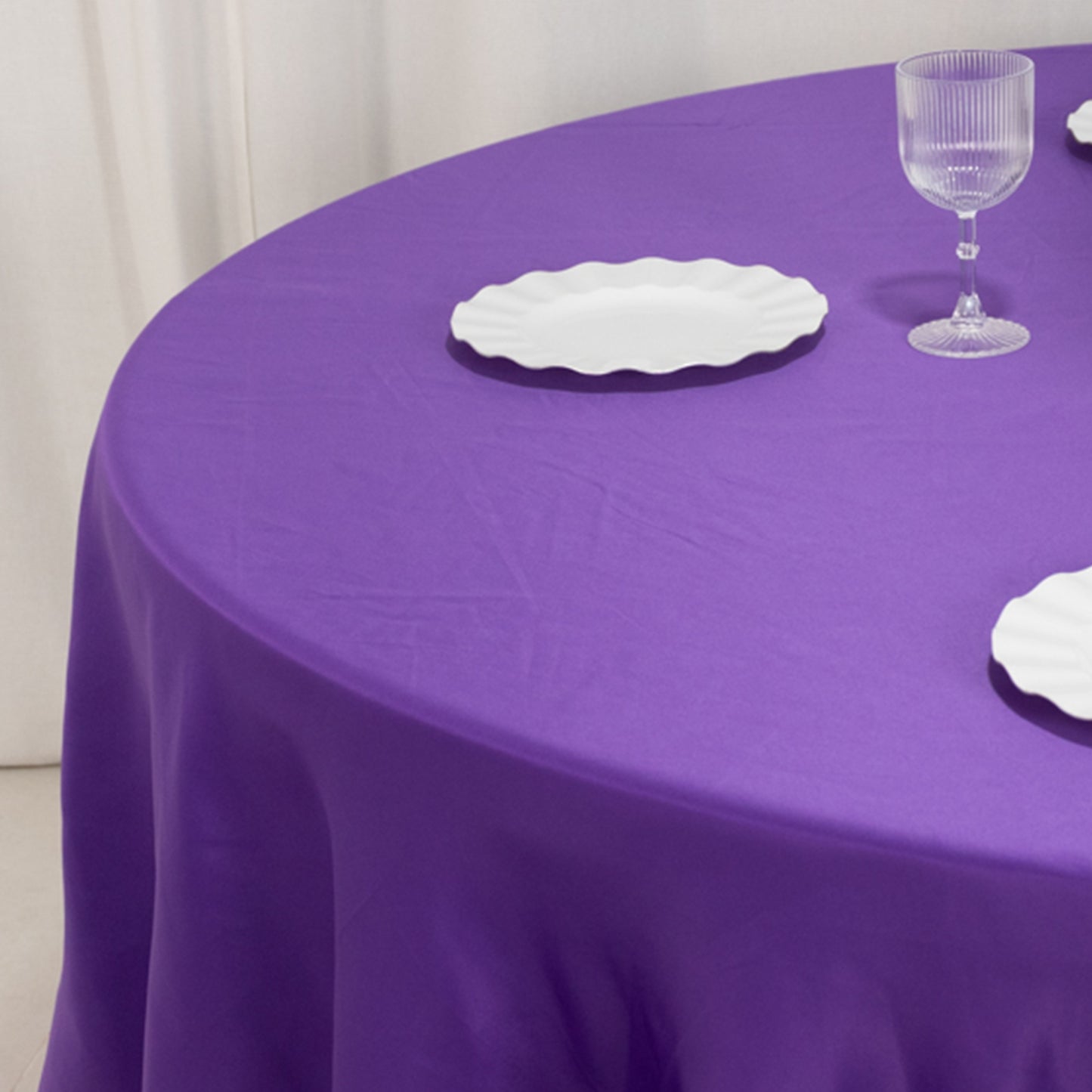 Purple satin round tablecloth on a dining table.