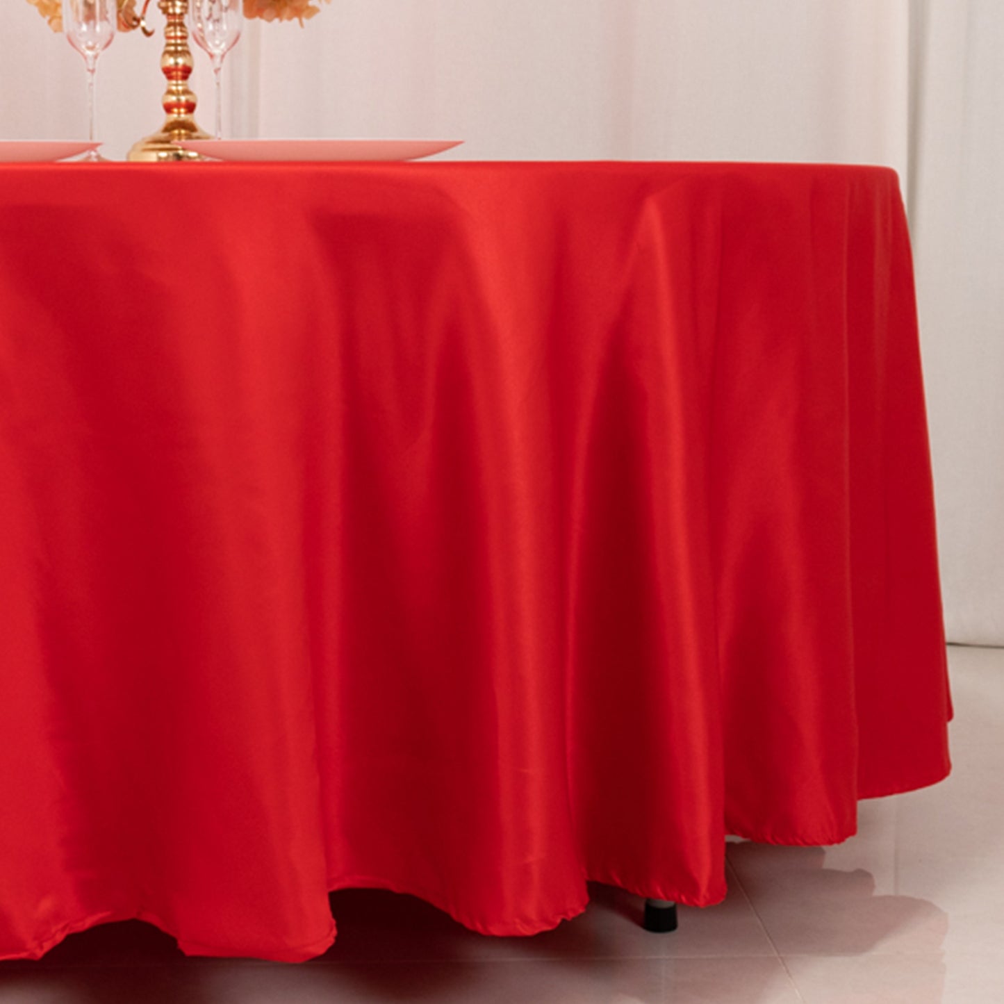 Red round satin tablecloth for elegant table settings.