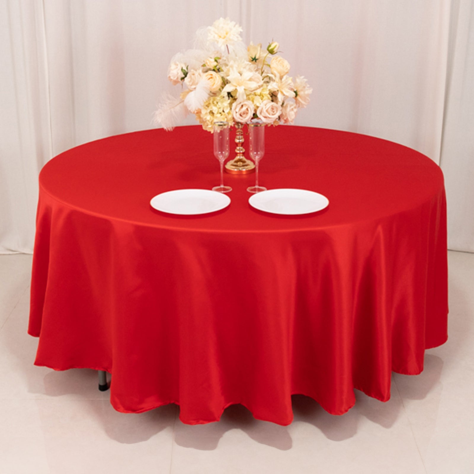 Red round satin tablecloth for elegant dining settings.