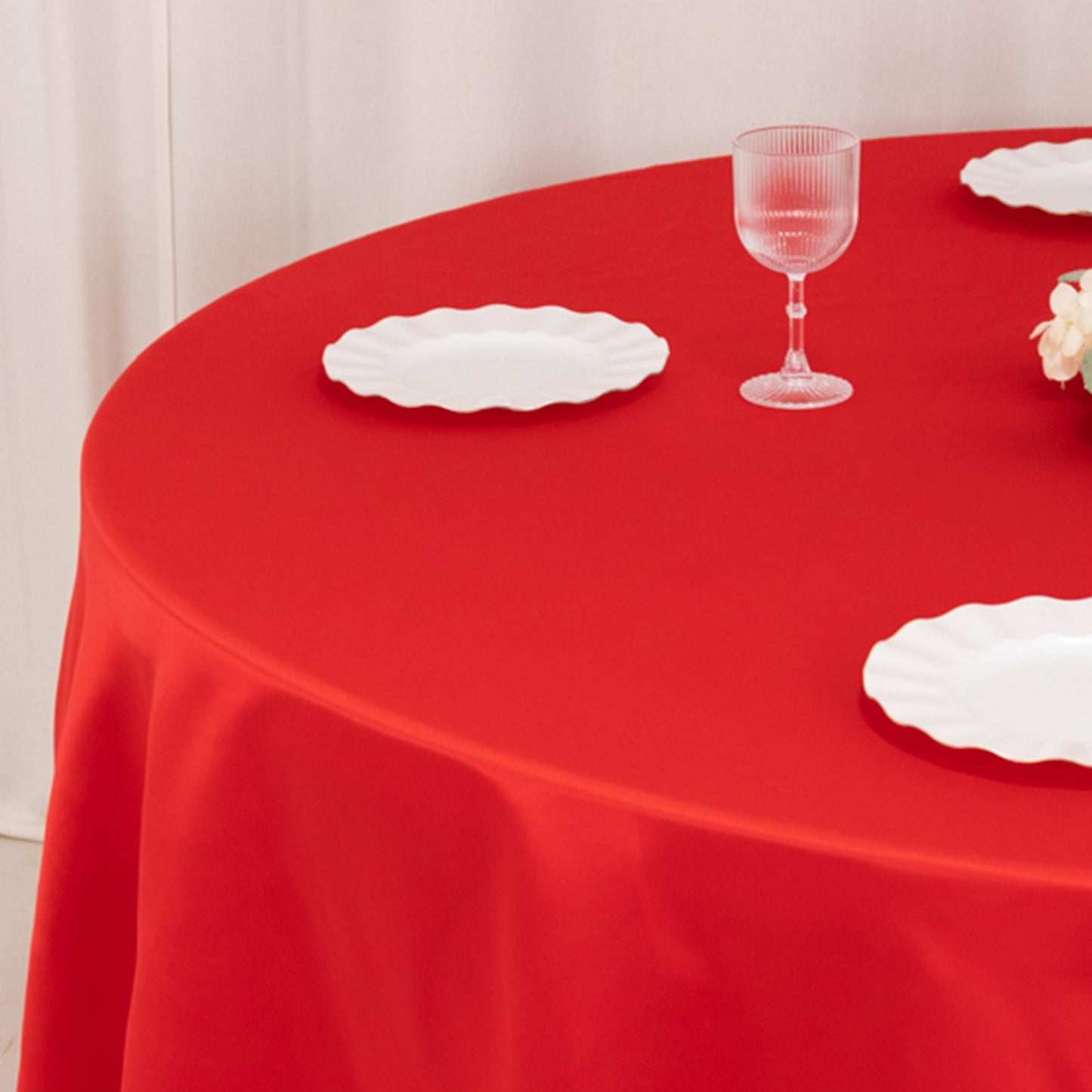 Red round tablecloth with elegant satin finish, perfect for events.