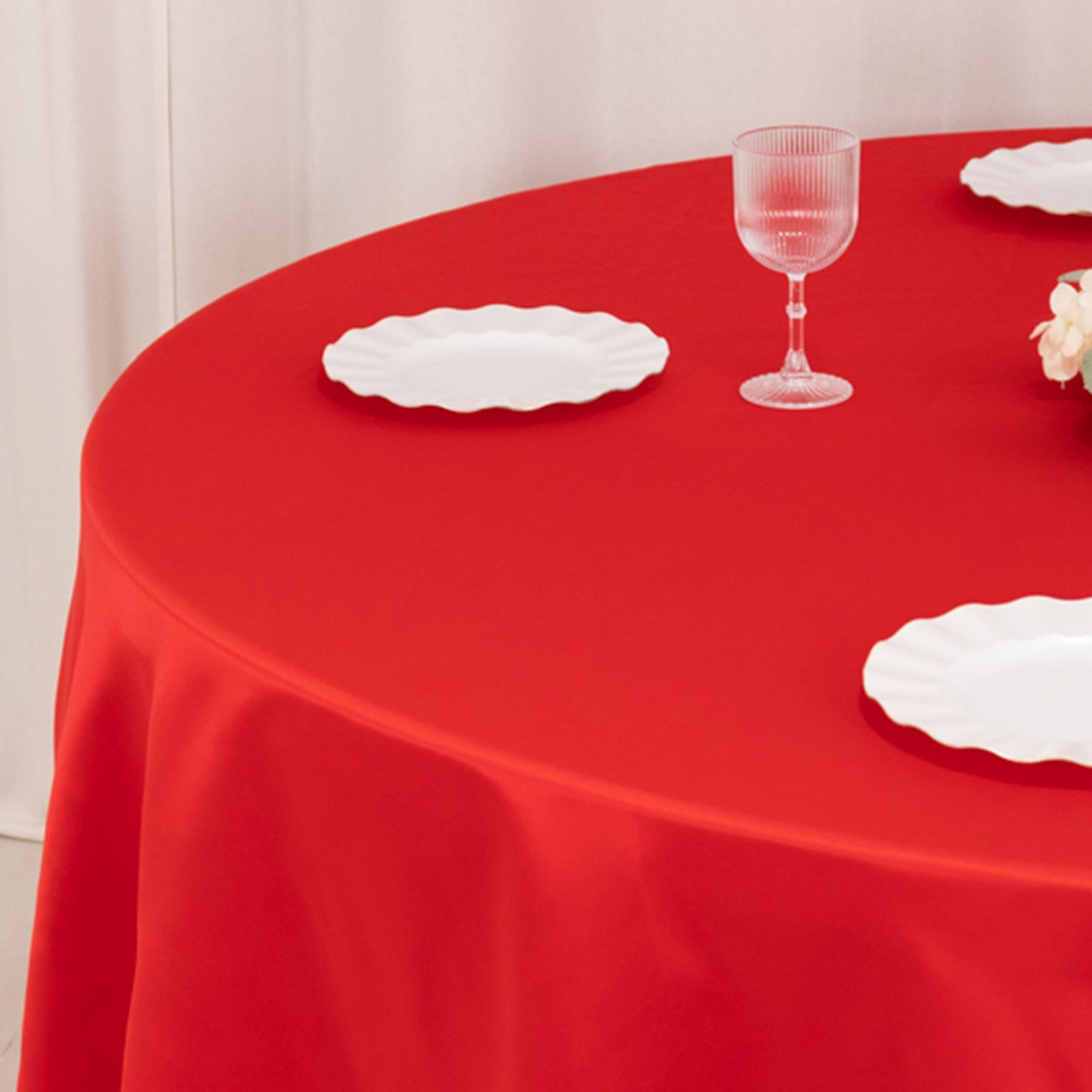 Red round tablecloth with elegant satin finish, perfect for events.