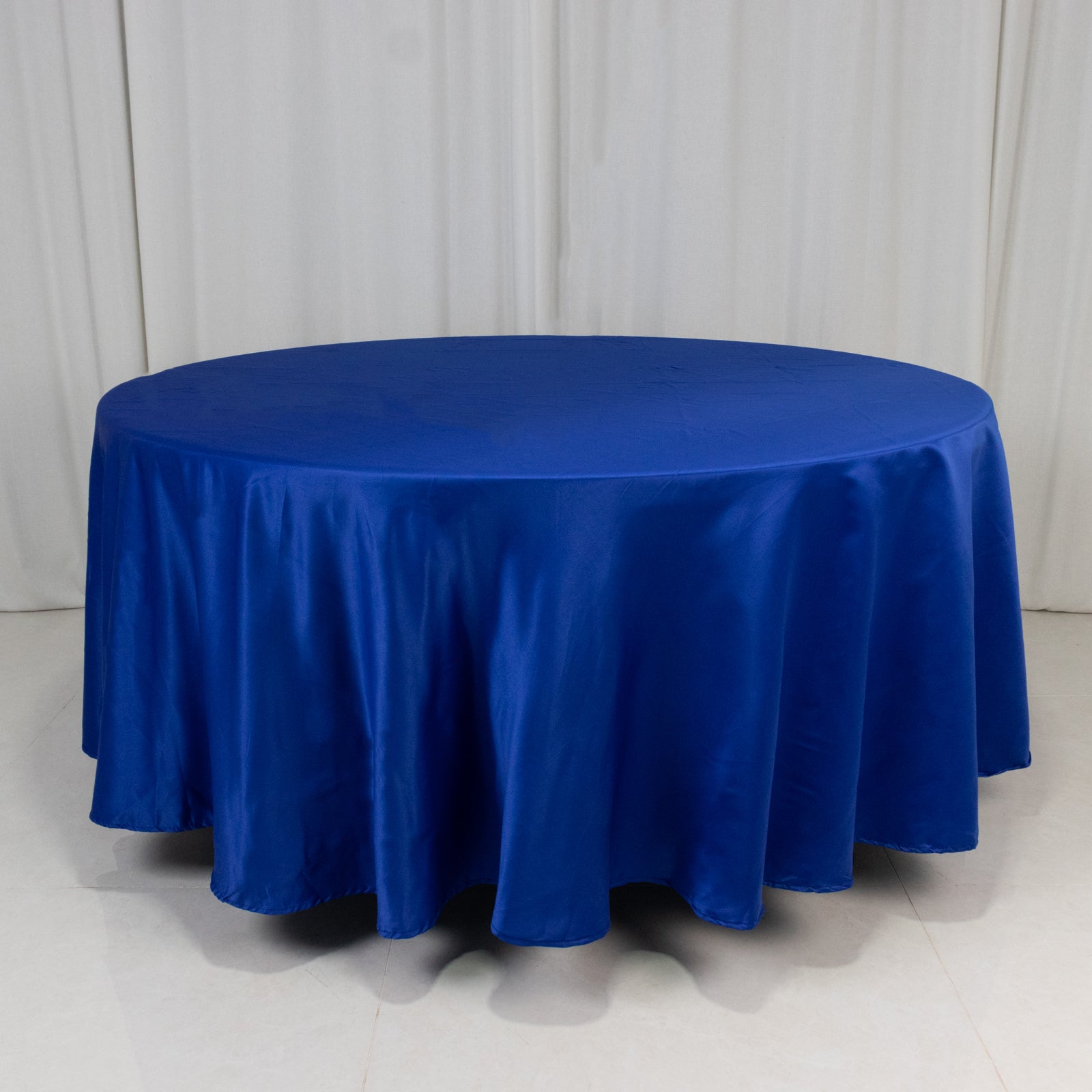 Royal blue satin round tablecloth on a table.