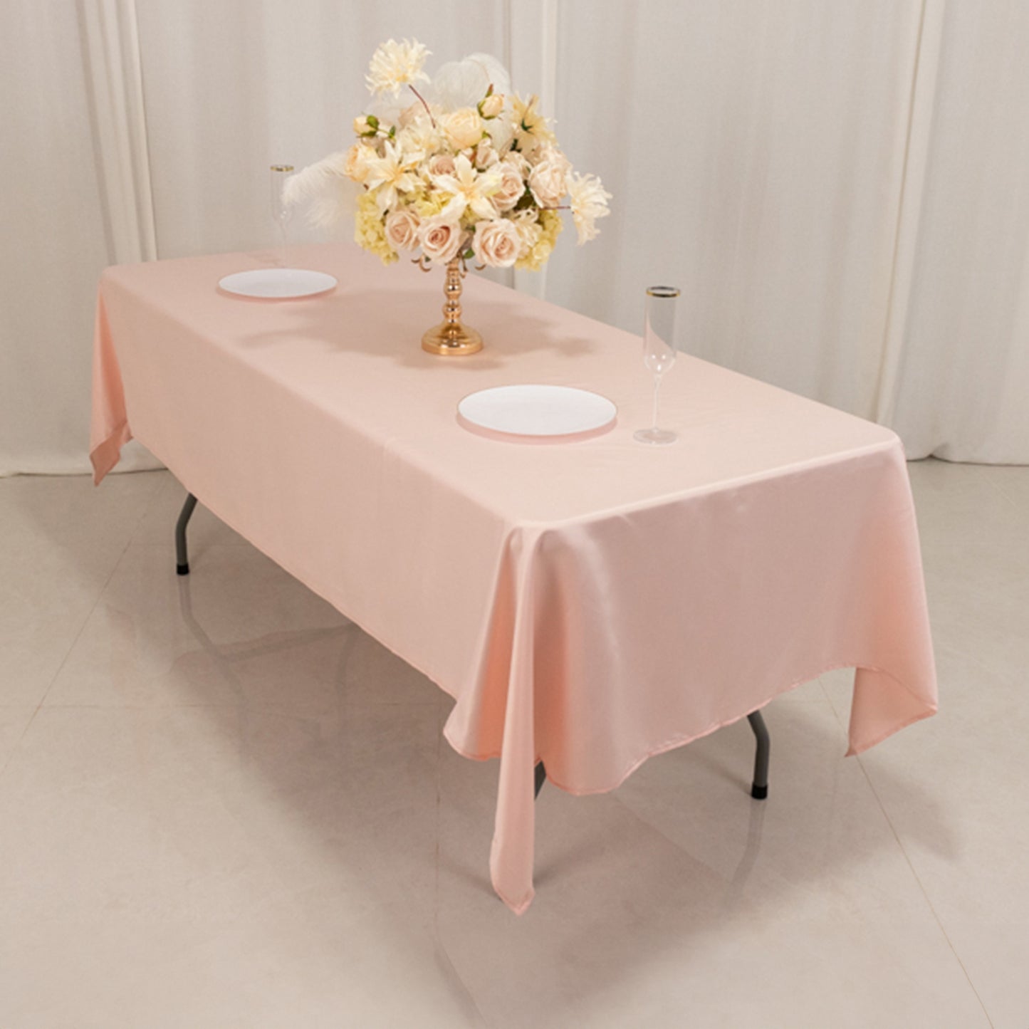 Blush satin rectangle tablecloth on a dining table with floral centerpiece.