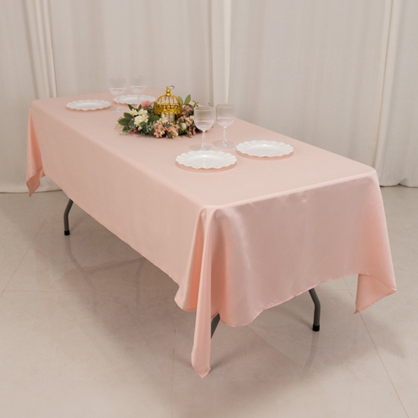 Blush satin rectangle tablecloth on a dining table with decor.