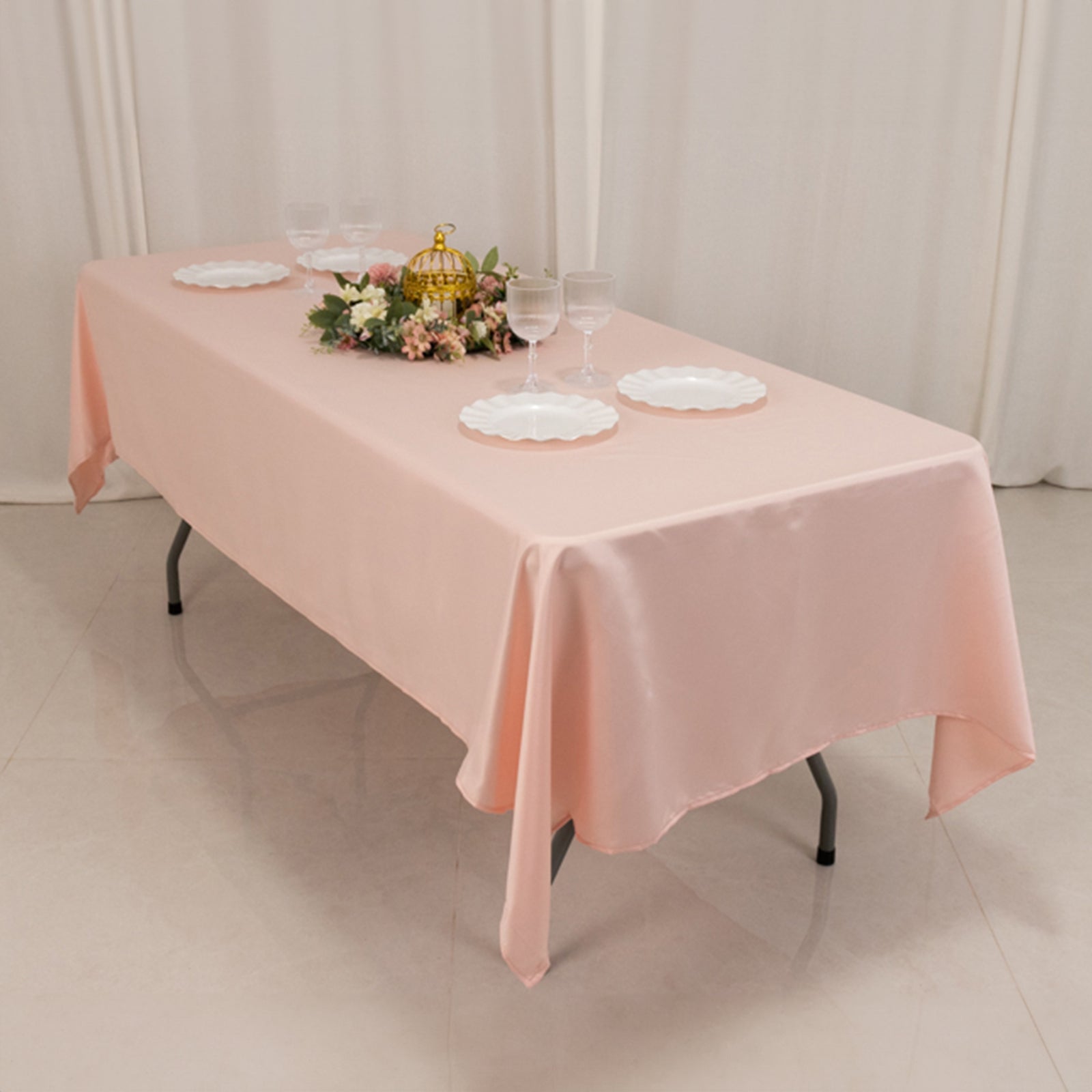 Blush satin rectangle tablecloth on a dining table with decor.