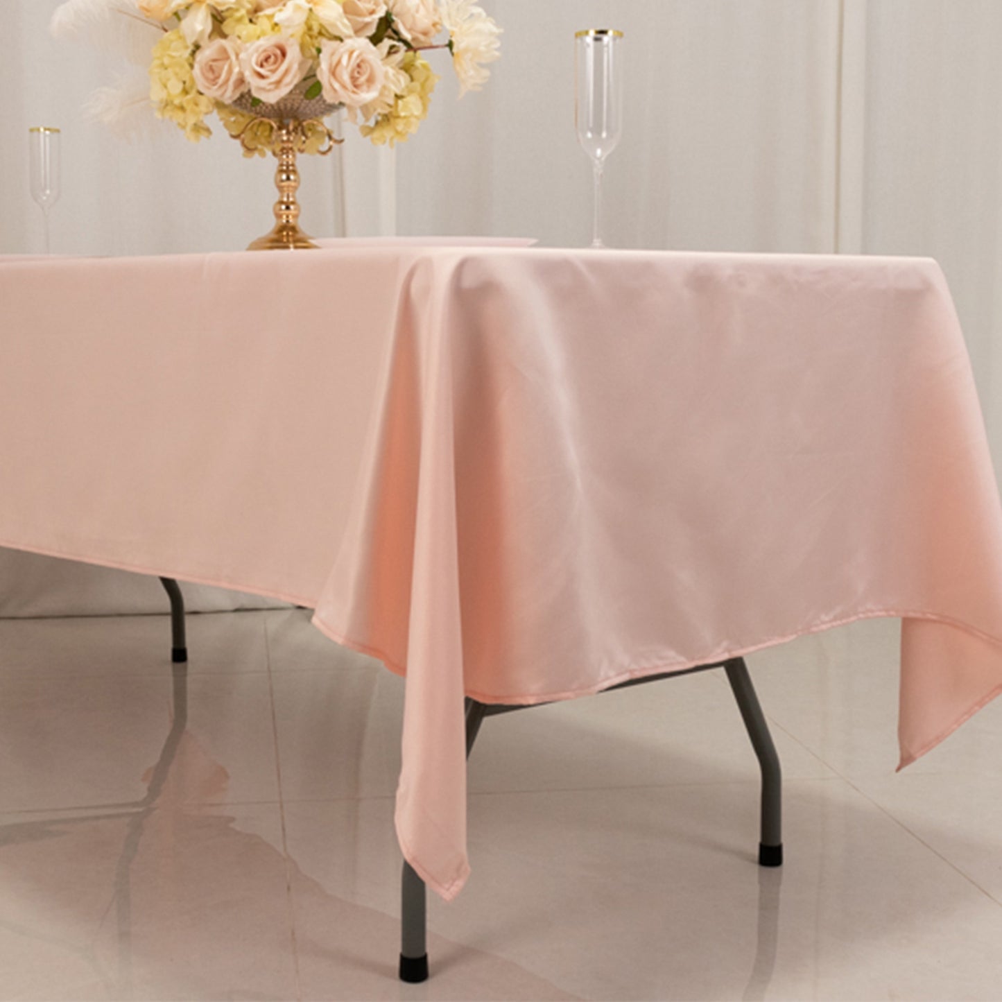 Blush satin rectangle tablecloth draping elegantly over a table.