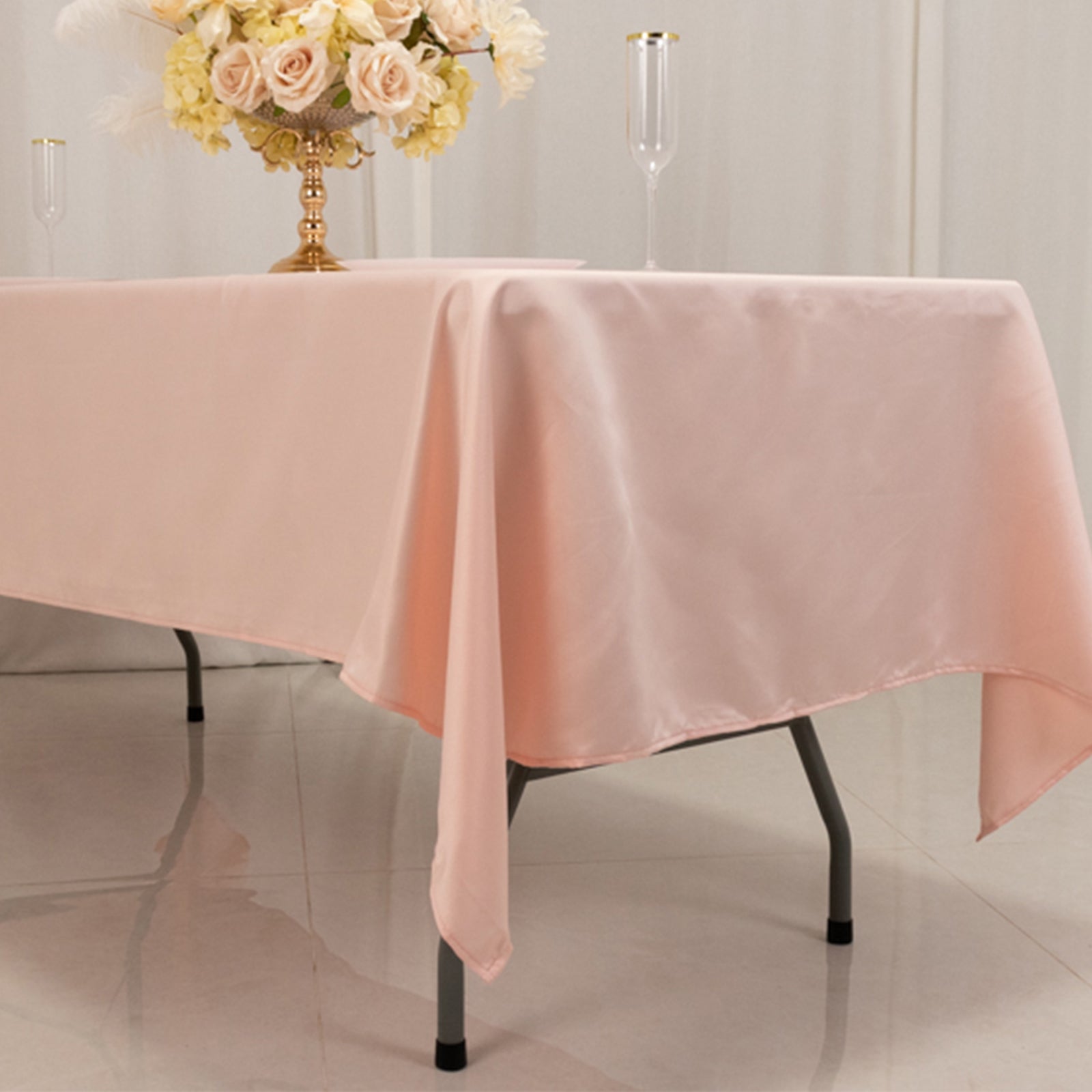 Blush satin rectangle tablecloth draping elegantly over a table.