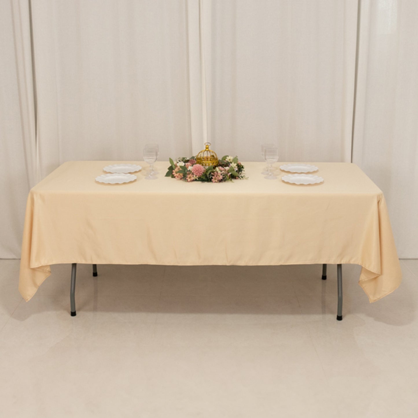 Beige satin rectangle tablecloth on a dining table with floral centerpiece.