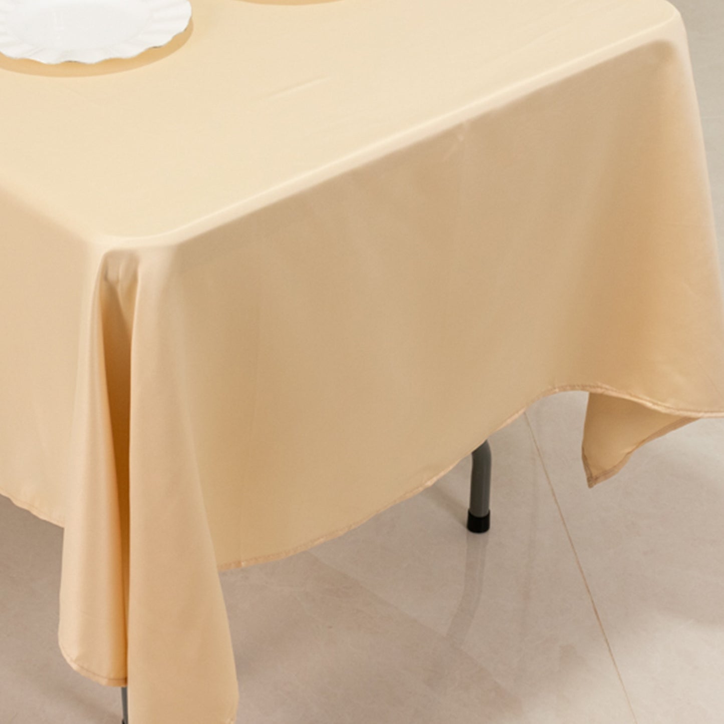 Beige Lamour satin rectangle tablecloth on a dining table.