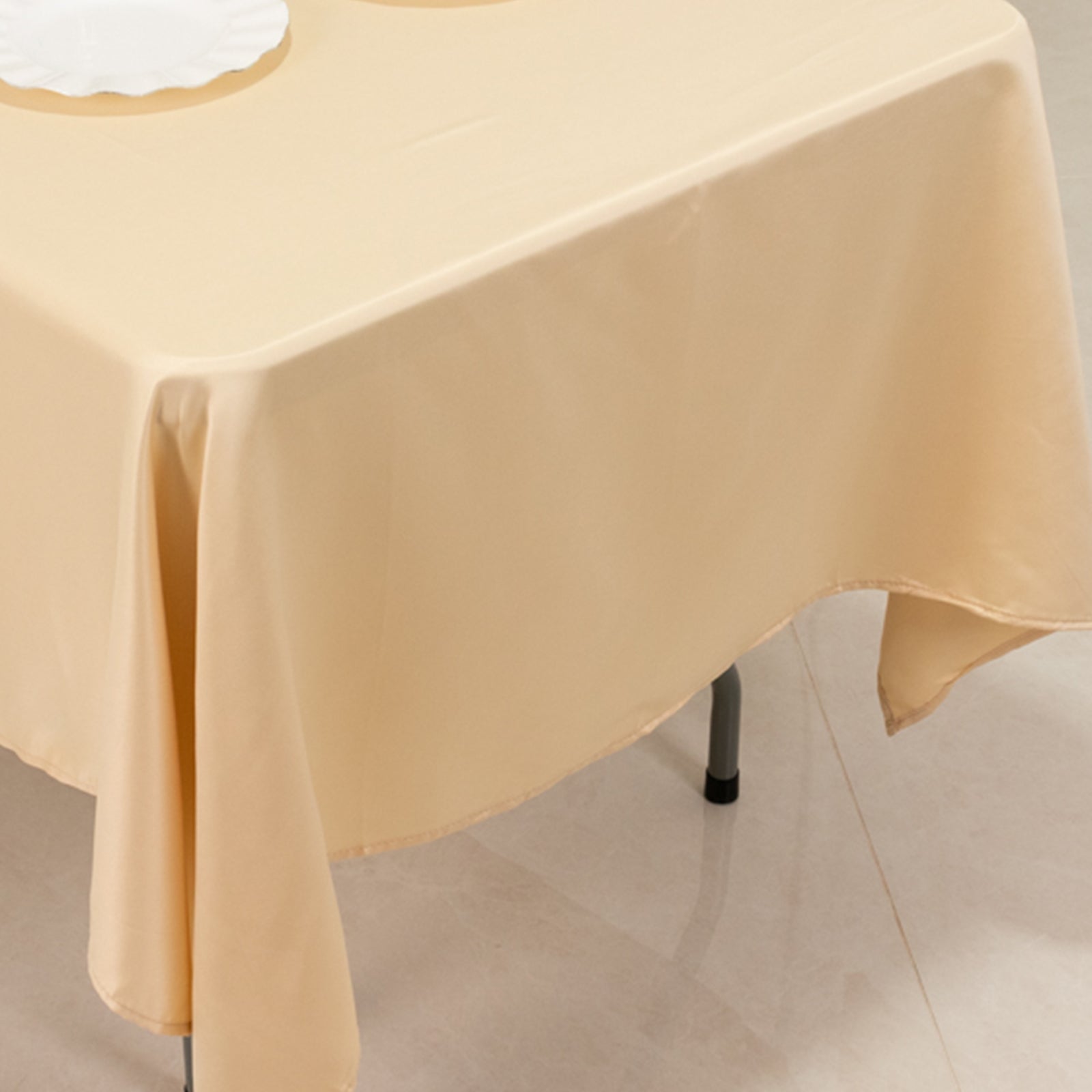 Beige Lamour satin rectangle tablecloth on a dining table.